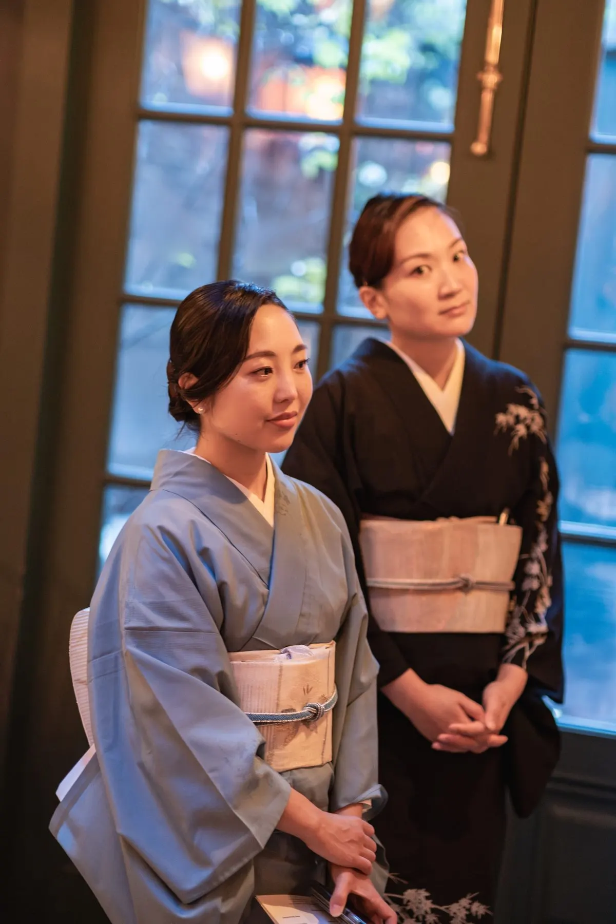 Two hosts in kimono by the window
