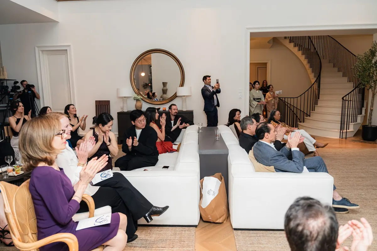 The audience applauding, the mirror and staircase behind