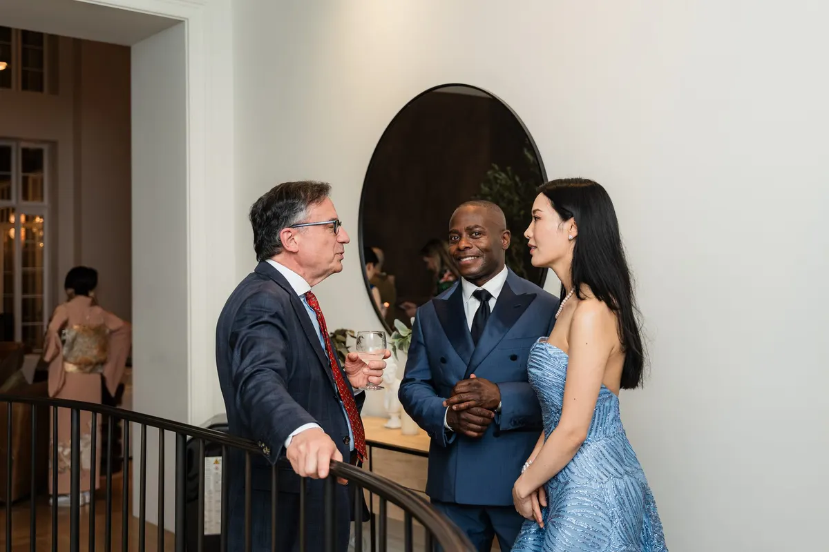 Anthony and Rieko talking with a guest at the stair railing