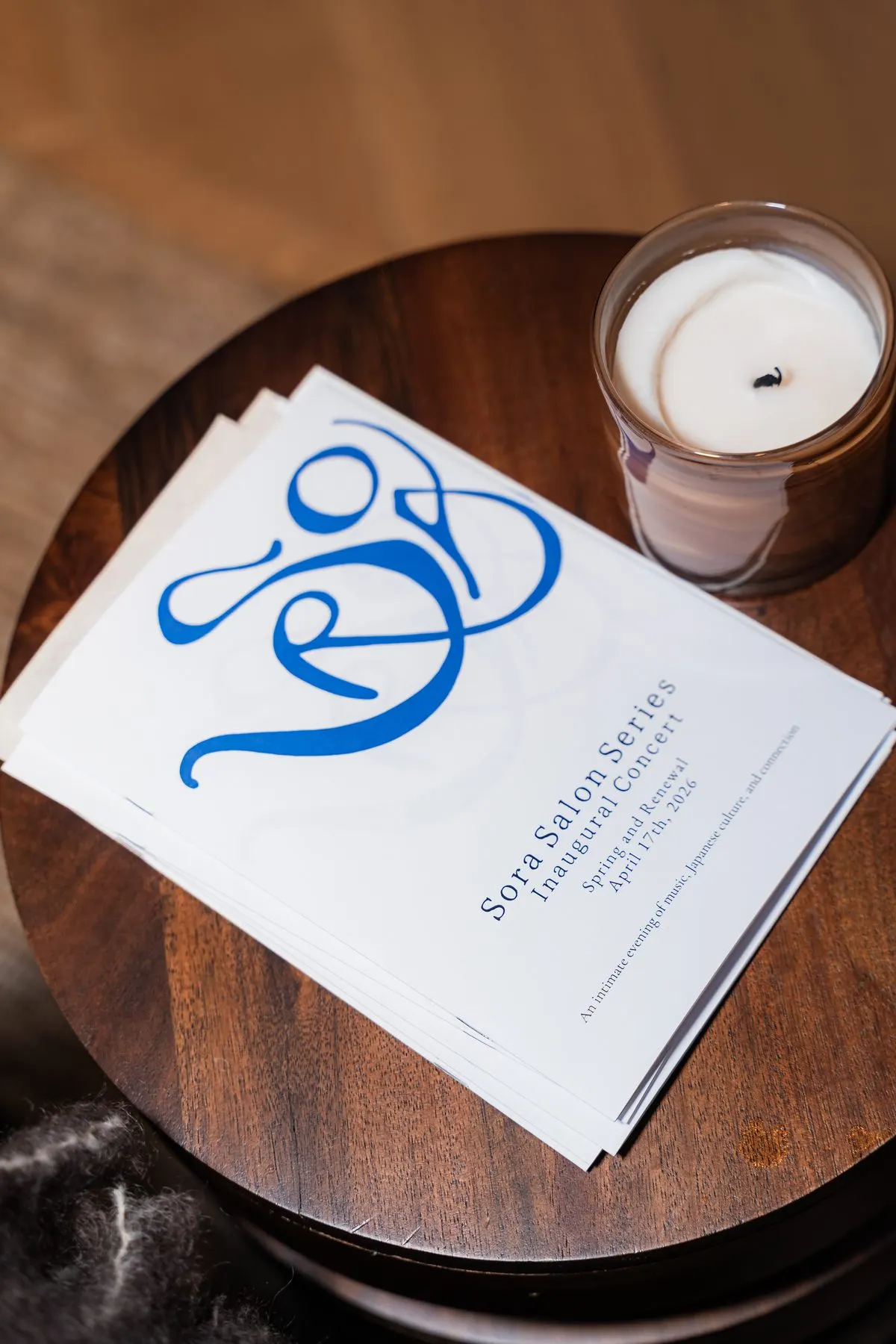 The evening’s printed program by a candle